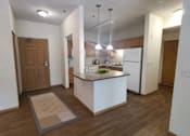 Thumbnail 13 of 37 - A kitchen with a white island and wooden floors.