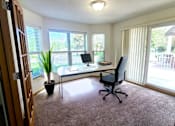 Thumbnail 18 of 37 - A room with a desk, chair, and potted plant.
