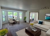 Thumbnail 16 of 37 - A living room with a white couch, a coffee table, and a painting on the wall.