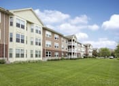 Thumbnail 35 of 37 - Apartment complex with a green lawn in front.