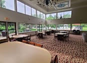 Thumbnail 11 of 37 - A large room with tables and chairs and a chandelier.