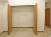 Thumbnail 20 of 37 - A room with a white wall and a wooden wardrobe with hanging rods.