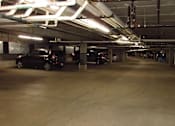 Thumbnail 23 of 37 - A parking garage with several cars parked.