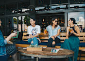 Thumbnail 2 of 2 - Four people are sitting at a table in a restaurant.