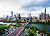 Thumbnail 1 of 2 - A cityscape with a river running through it.