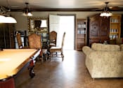 Thumbnail 27 of 38 - A living room with a pool table and a couch.