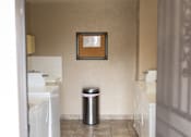 Thumbnail 35 of 38 - A hallway with a trash can and a picture on the wall.