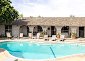 Thumbnail 2 of 38 - A pool with chairs around it.
