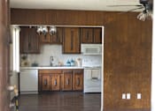 Thumbnail 23 of 38 - A kitchen with wooden cabinets and a white dishwasher.