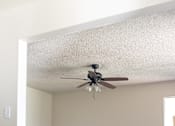 Thumbnail 8 of 38 - A room with a ceiling fan and wooden floors.
