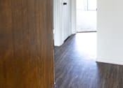 Thumbnail 13 of 38 - A hallway with a white door and a brown wood panelled wall.