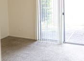 Thumbnail 10 of 38 - A room with a ceiling fan and sliding glass doors.
