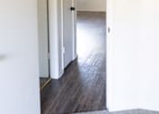 Thumbnail 9 of 38 - A hallway with a white door and a window.