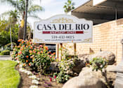Thumbnail 30 of 38 - A sign for Casa Del Rio Apartments is displayed in front of a building.