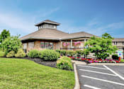 Thumbnail 1 of 15 - A building with a parking lot in front of it.
