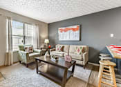 Thumbnail 6 of 15 - A living room with a couch, chair, and coffee table.