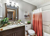 Thumbnail 8 of 15 - A bathroom with a toilet, sink, and a shower curtain.
