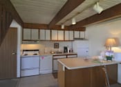 Thumbnail 19 of 20 - A kitchen with white appliances and wooden cabinets.