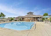 Thumbnail 3 of 15 - A large outdoor swimming pool with a pavilion in the background.