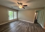 Thumbnail 16 of 18 - A room with a ceiling fan and sliding glass doors.