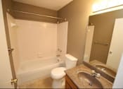 Thumbnail 4 of 18 - A bathroom with a toilet, sink, and bathtub.