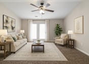 Thumbnail 1 of 18 - A living room with a beige sofa, a coffee table, and a ceiling fan.