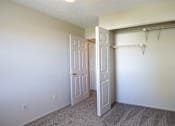 Thumbnail 4 of 20 - A room with a white door and a white closet with a hanger rod.