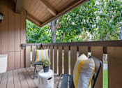 Thumbnail 12 of 57 - a covered porch with two chairs and a table