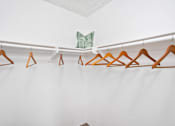 Thumbnail 35 of 57 - a closet with wooden clothes hangers and a metal angel on the wall
