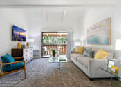 Thumbnail 4 of 57 - a living room with a gray couch and a glass coffee table