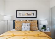 Thumbnail 11 of 35 - a bedroom with a yellow bed and yellow pillows and a picture on the wall
