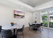 Thumbnail 17 of 38 - a dining room with a table and chairs and a large window