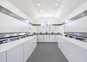 Thumbnail 43 of 43 - A laundromat with rows of washers and dryers.