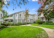 Thumbnail 19 of 49 - the view of an apartment building with a sidewalk and green grass