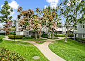 Thumbnail 26 of 49 - an apartment building with trees and a sidewalk