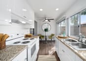 Thumbnail 8 of 29 - a kitchen with white cabinets and granite counter tops