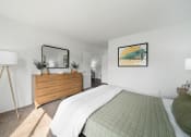 Thumbnail 10 of 29 - a bedroom with a bed and a dresser and a mirror