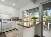 Thumbnail 36 of 57 - a kitchen with white cabinets and a large window