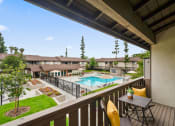Thumbnail 11 of 57 - a balcony with a table and chairs and a swimming pool in the background
