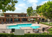 Thumbnail 20 of 29 - a swimming pool and patio with chairs and umbrellas in front of a house