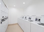 Thumbnail 27 of 29 - a washer and dryer room with white appliances and white walls