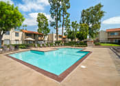 Thumbnail 22 of 29 - a swimming pool with trees and apartments in the background