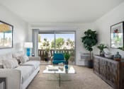 Thumbnail 50 of 57 - a living room with a white couch and coffee table and a sliding glass door leading to a