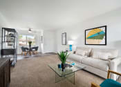 Thumbnail 47 of 57 - a living room with a couch coffee table and a dining room table in the background