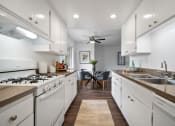 Thumbnail 52 of 57 - a kitchen with white cabinetry and a white stove top oven