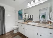 Thumbnail 10 of 57 - a bathroom with white cabinets and a large mirror