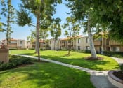 Thumbnail 23 of 29 - a view of the grounds of an apartment building with grass and trees