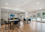 Thumbnail 18 of 57 - a resident clubhouse with tables and chairs and a pool in the background