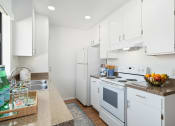 Thumbnail 12 of 41 - a white kitchen with white appliances and white cabinets