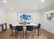 Thumbnail 17 of 57 - a dining room with a table and chairs and a painting on the wall